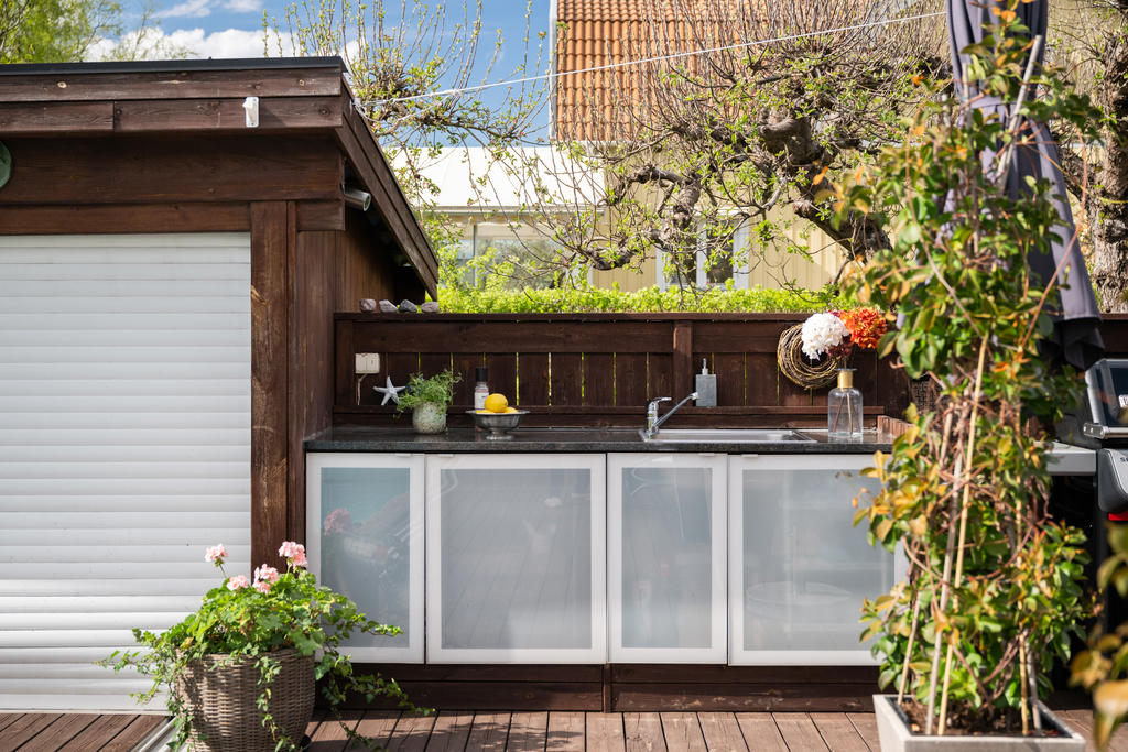 Intill det stilfulla poolhuset finns ett exklusivt utomhuskök som skapar den perfekta miljön för sommarens middagar, sociala tillställningar och långa kvällar med familj och vänner.