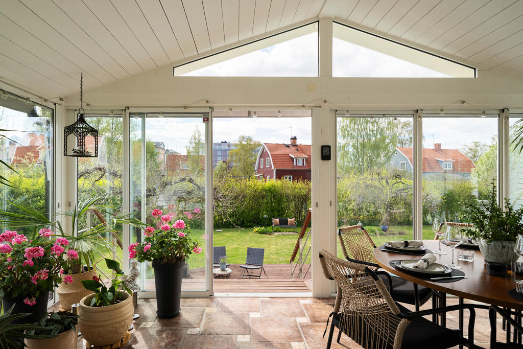 Stort inglasat uterum med vackert klinkergolv med inslag av sjösten som skapar en exklusiv och naturnära känsla. De eleganta panoramadörrarna suddar ut gränsen mellan inne och ute och släpper in rikligt med ljus. Här finns gott om plats för ett större matbord och sociala tillställningar året om.