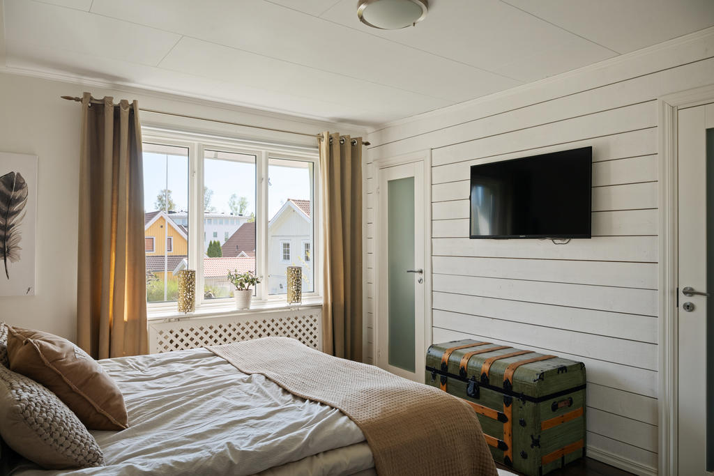 Master Bedroom med inbyggd klädkammare och en vacker öppen spis som skapar en varm och exklusiv hotellkänsla. Ett rofyllt och elegant rum där komfort och atmosfär möts på bästa sätt.