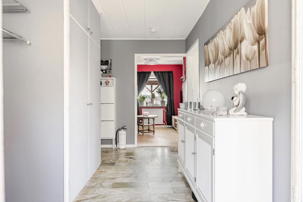 Rymlig entréhall med stengolv och garderober.