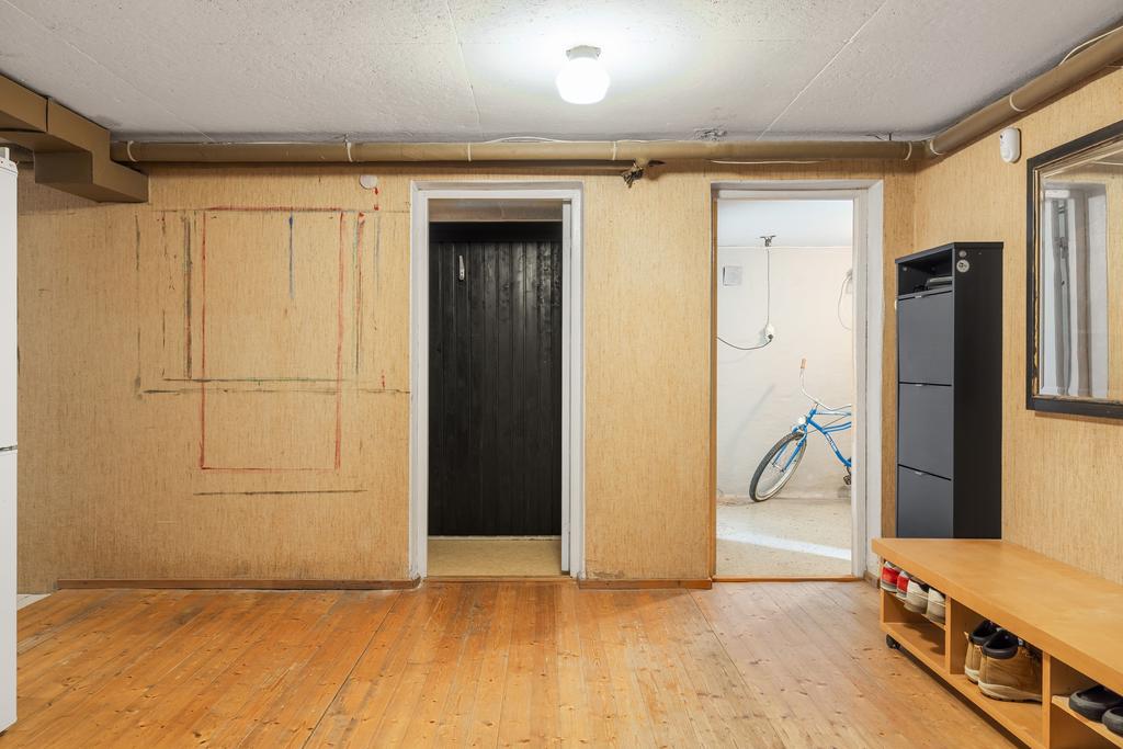 Källarplan med ingång till en liten spa-yta samt cykelförråd och garage.