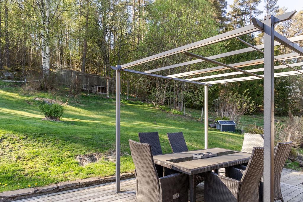 På baksidan omfamnar skogen fastigheten och skapar en mysig utemiljö