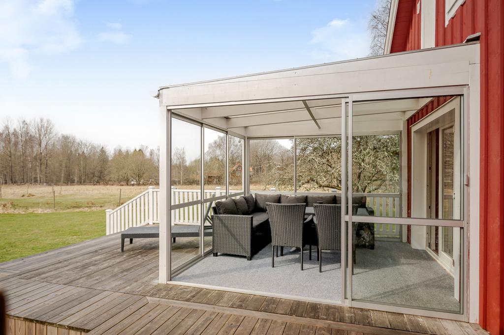 Inglasad altan med uteplats framför