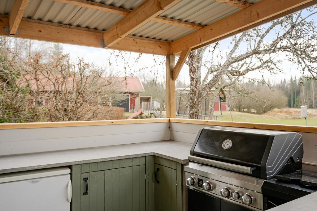 Utekök med bänkskåp, betongbänskiva, liten kyl och grill