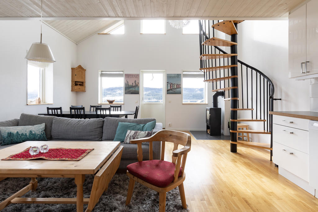 Vardagsrum och kök i öppen planlösning med generös takhöjd