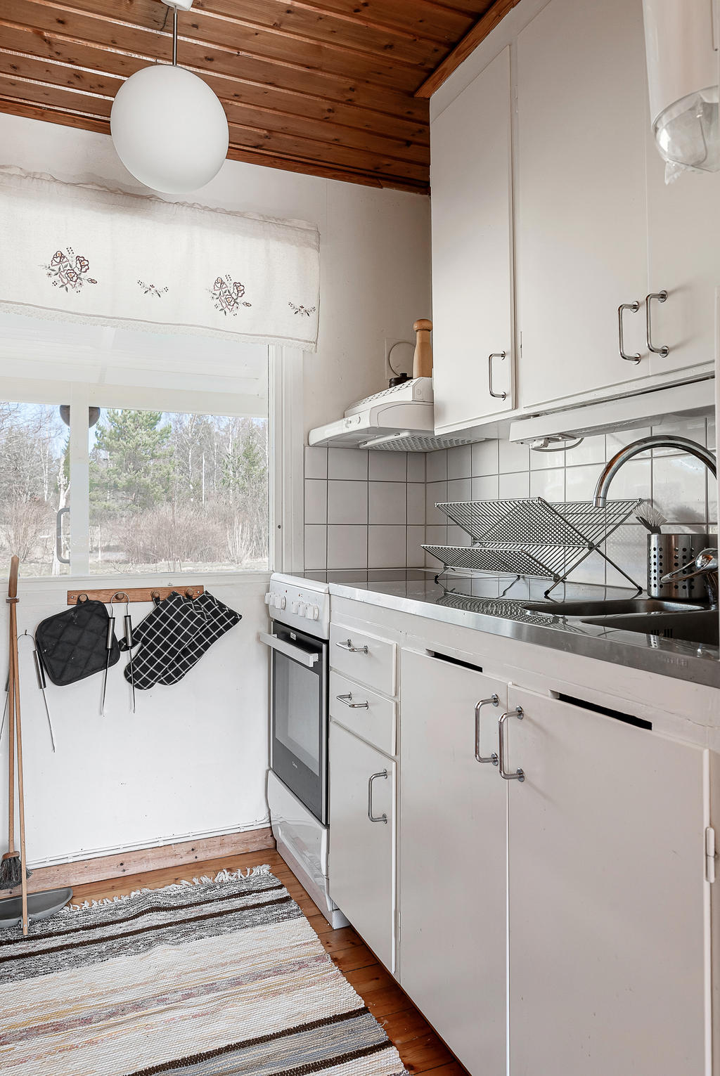 Kök i vårdat skick, smal spishäll och diskbänk i rostfritt stål