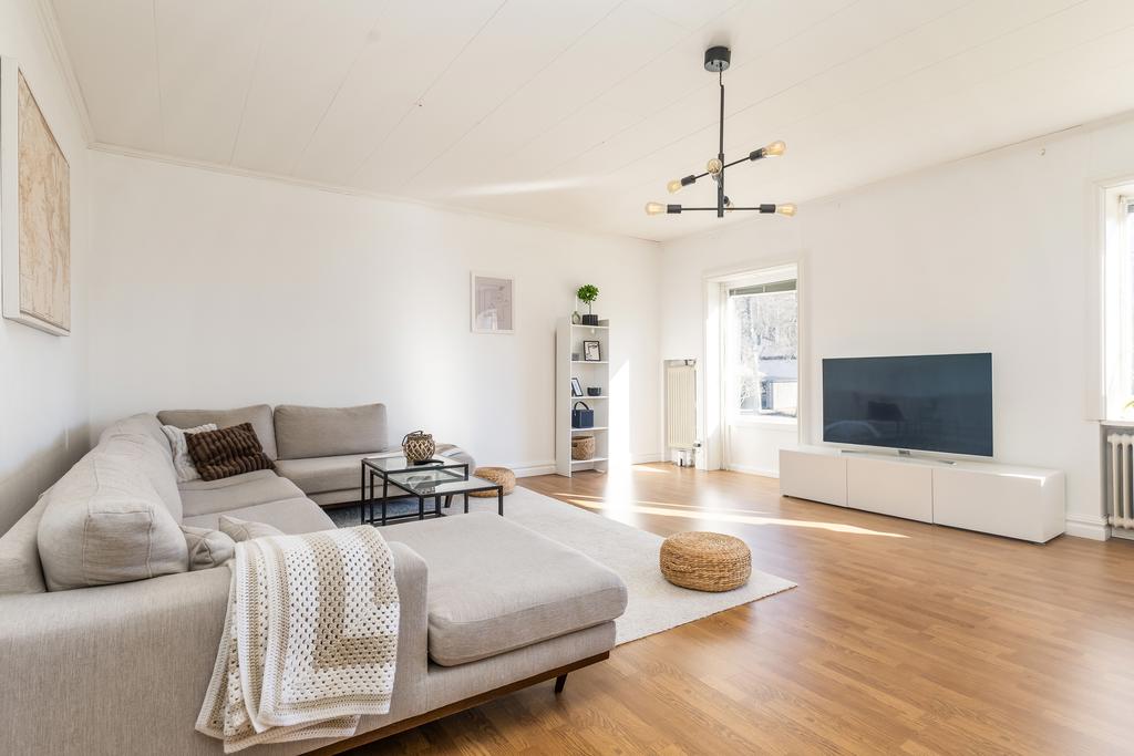 Vardagsrum med öppen spis och utgång till baksida.