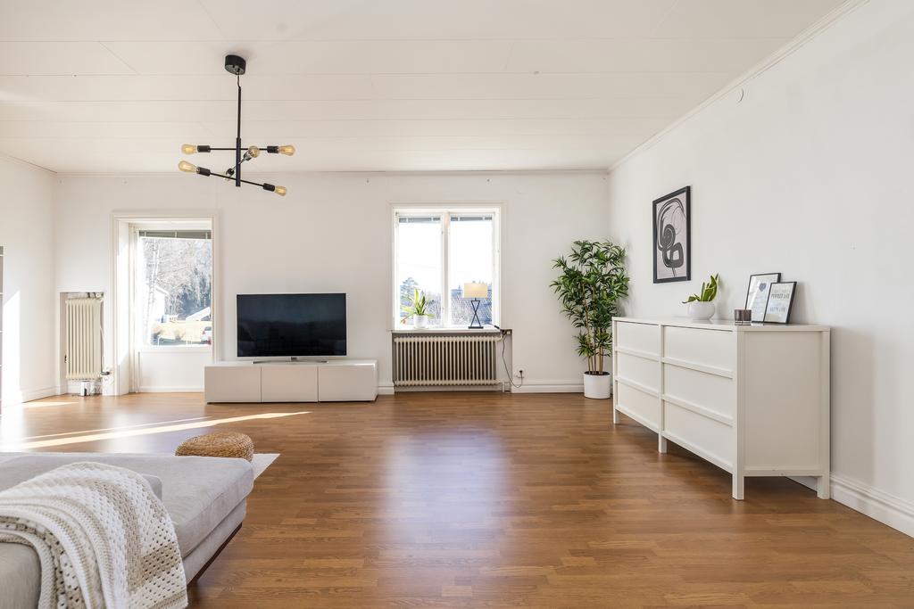 Vardagsrum med öppen spis och utgång till baksida.