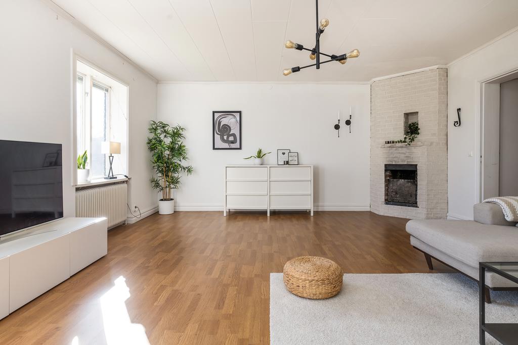 Vardagsrum med öppen spis och utgång till baksida.