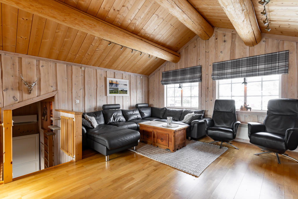 Rymligt vardagsrum med synliga takbjälkar