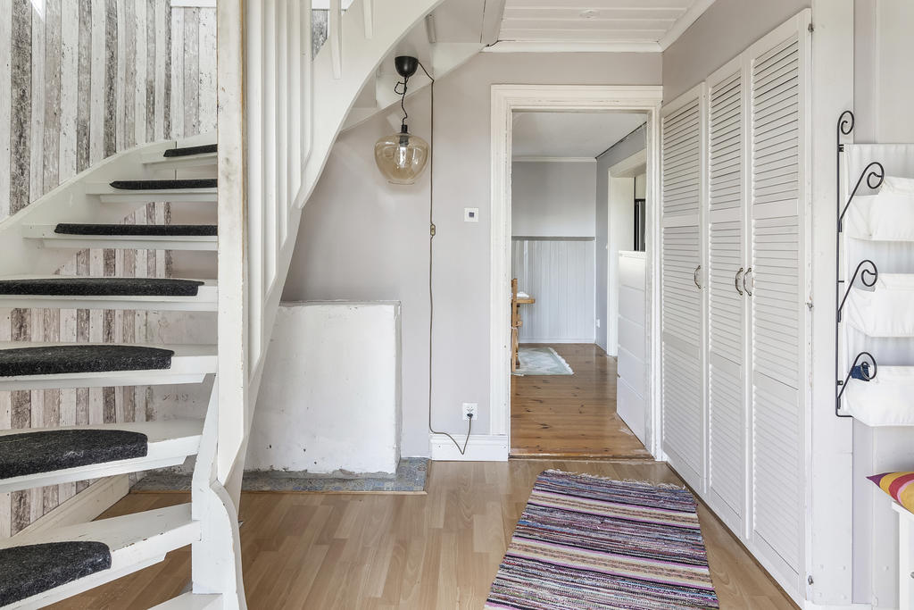 Hall med trapp till övre plan och gott om förvaringsmöjligheter