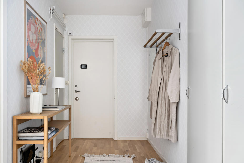 Hall med plats för avhängning samt platsbyggda garderober.