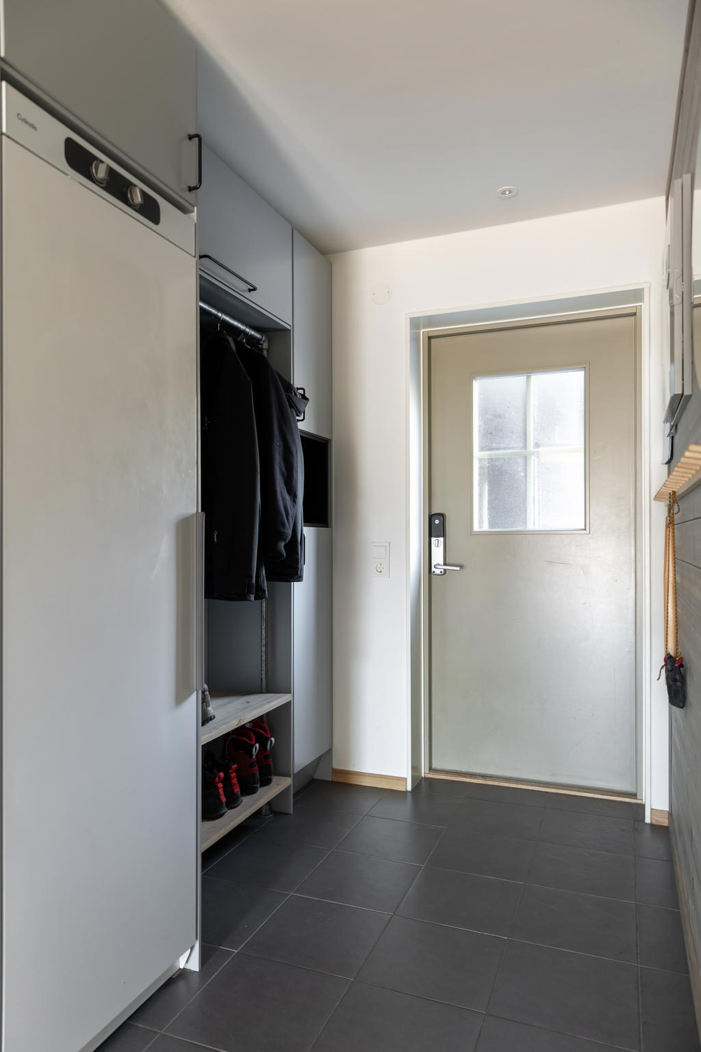 Golvvärme, klinker, torkskåp och praktisk förvaring i hallen.