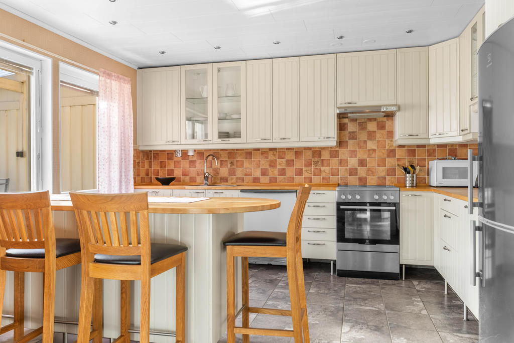 Ljust kök, renoverat 2006, med köksö och utgång till takad altan