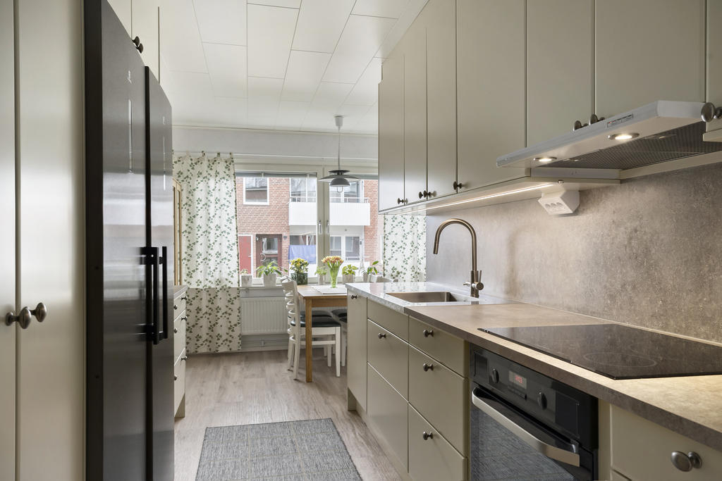 Snyggt med fullstor kyl och frys i mörk nyans mot det beiga köket. 