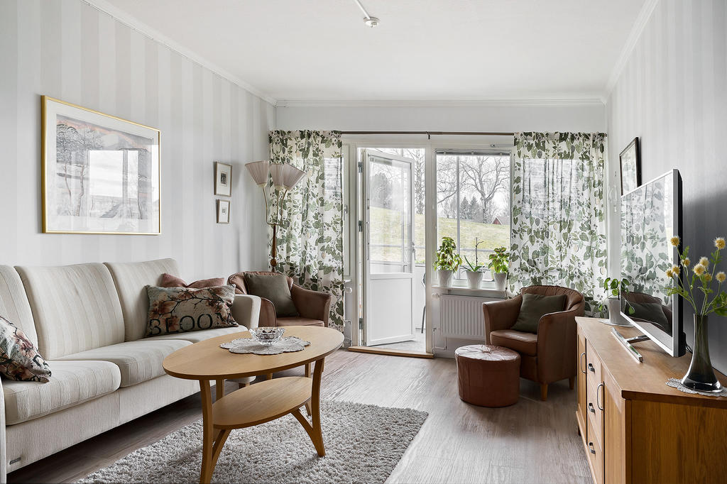 Vardagsrummet går i samma harmoniska färger och här tar du dig vidare till den stora inglasade balkongen med utgång till gräsmattan. 