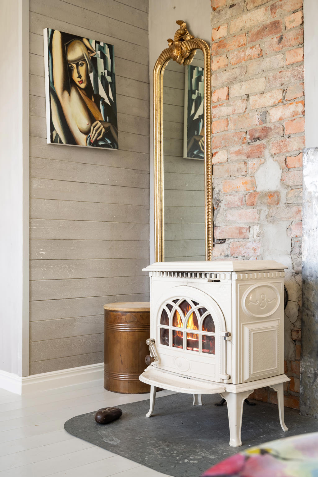 Värmande kamin  i vardagsrum på övre plan.