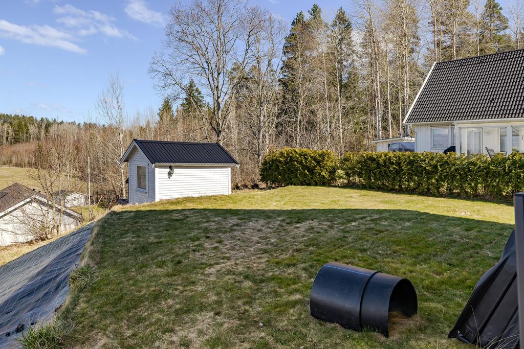 Gräsytor på sidan av huset. Isolerad friggebod finns också.  
