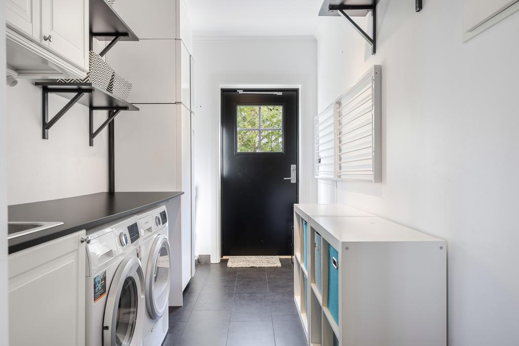 Tvättstuga med groventre intill hallen. 