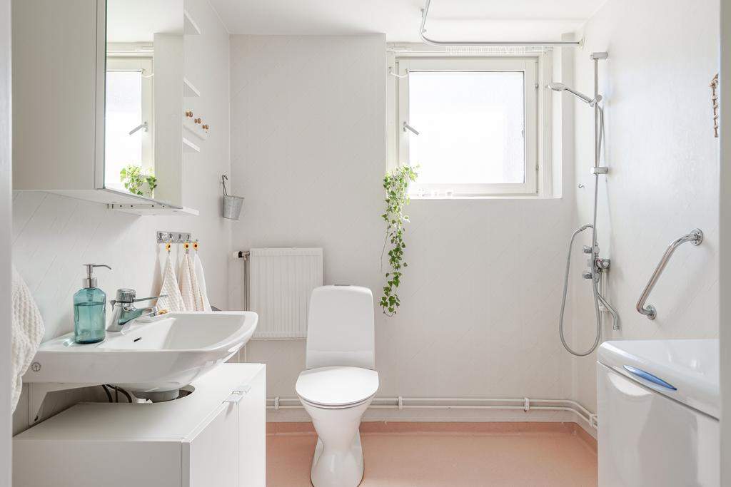 Duschrum med stort vädringsfönster och toppmatad tvättmaskin