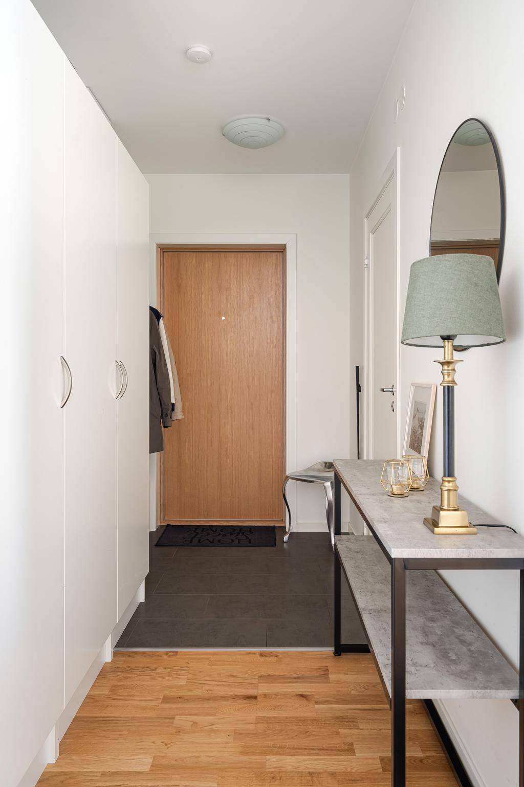 Hall med gott om garderobsförvaring samt klinkergolv