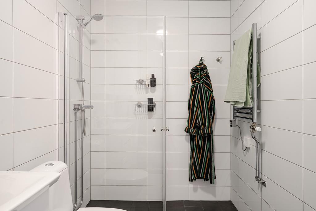 Dusch med vikväggar i glas samt elektrisk handdukstork