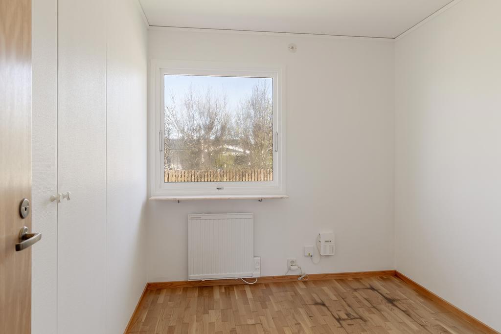 Mindre sovrum med inbyggda garderober som kan användas som barnrum eller arbetsrum.