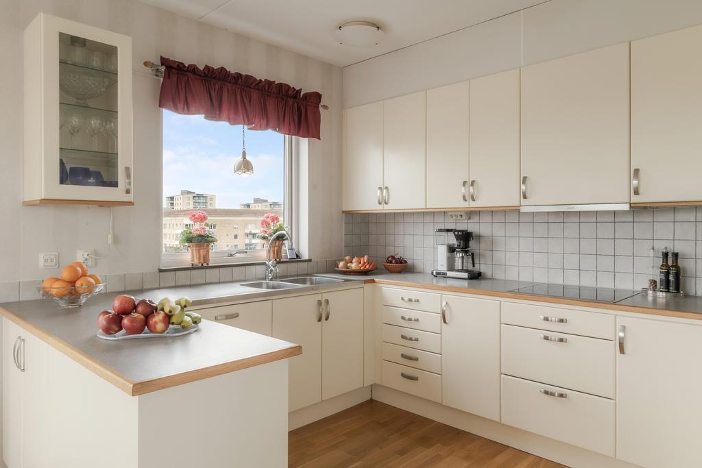 Kök med lackerade köksluckor i en svag ljusgul nyans