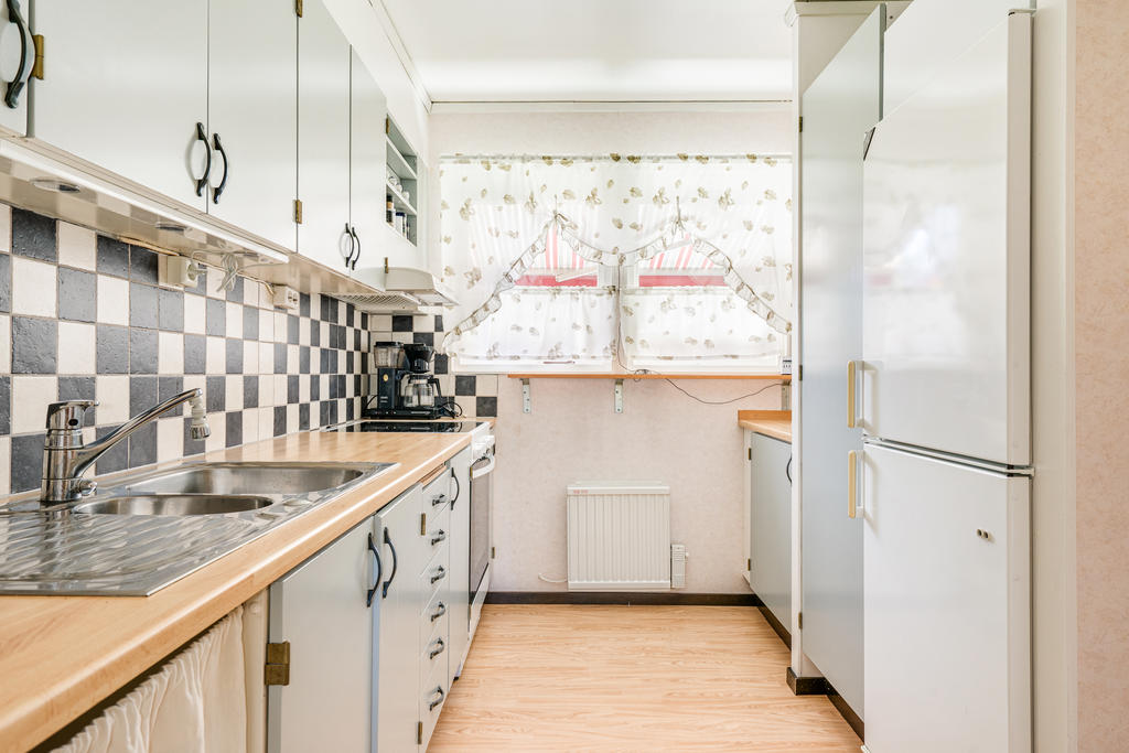 Funktionellt kök med målade luckor.