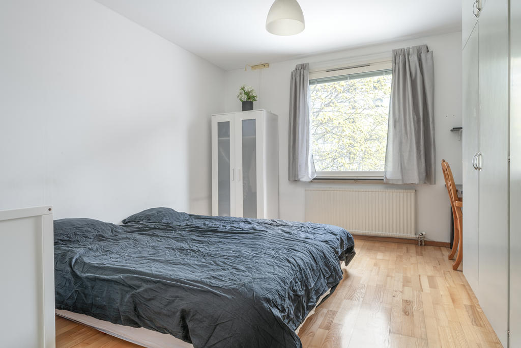 Rymligt sovrum med platsbyggda garderober.