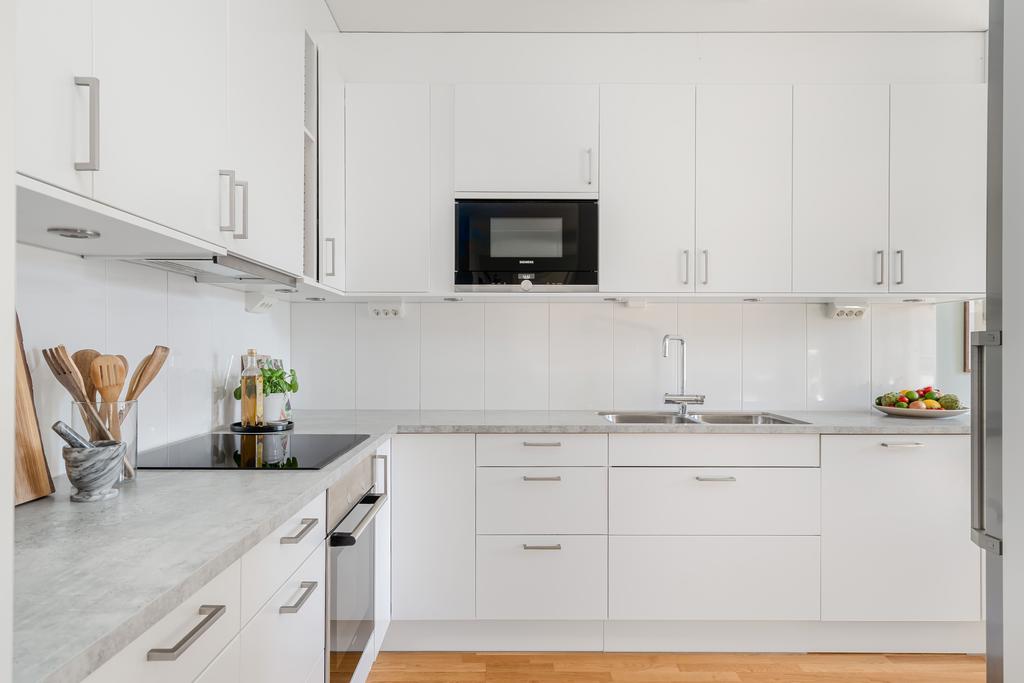 Helt i vitt och grått med rostfria vitvaror och integrerad diskmaskin