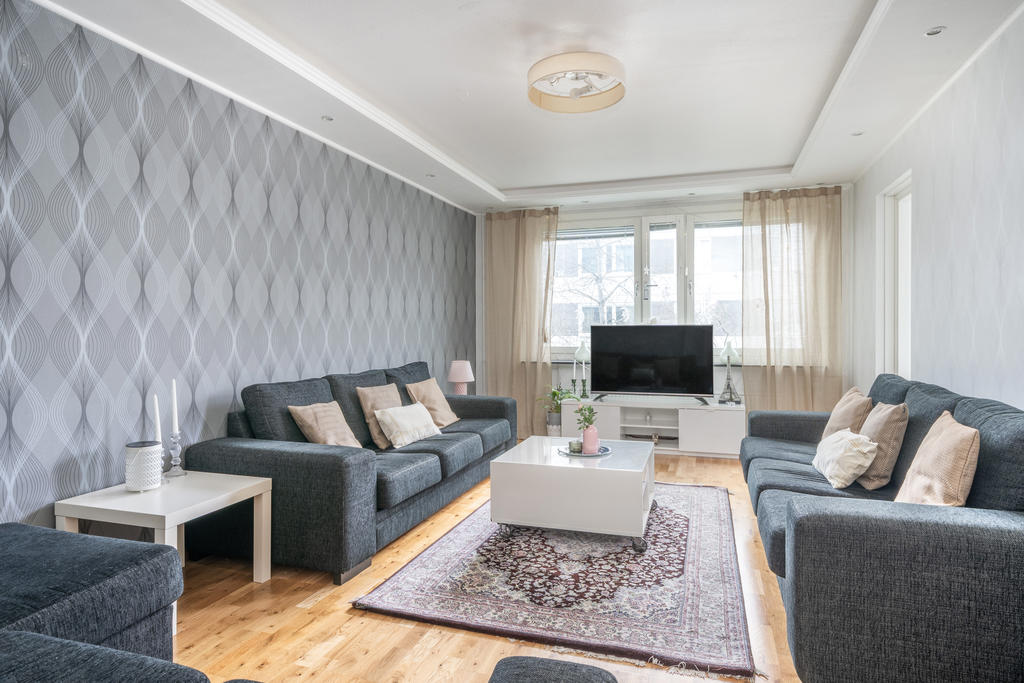 Rymligt vardagsrum med vackert parkettgolv. Här ryms det stora sällskapet.