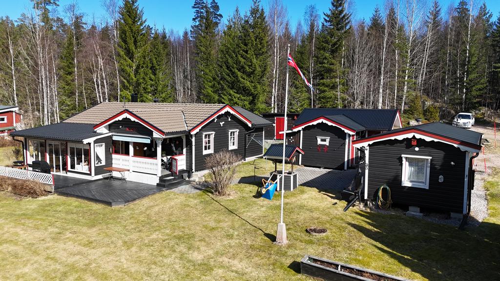 Drönarbild med huvudbyggnad , garage och gäststuga.