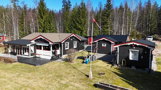 Drönarbild med huvudbyggnad , garage och gäststuga.