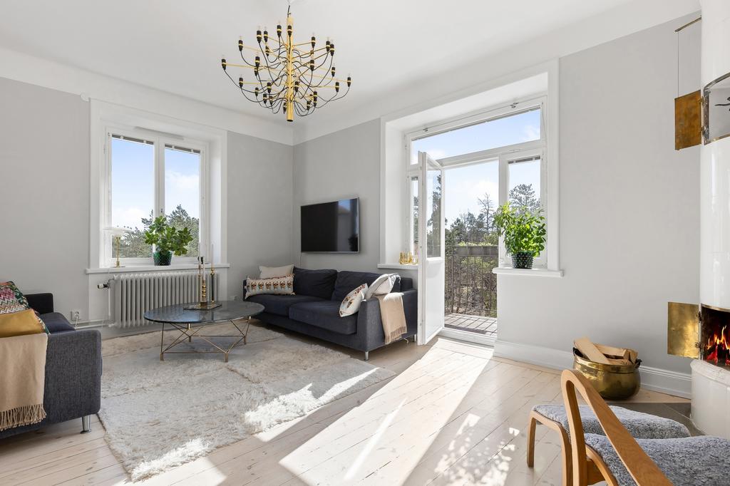 Vardagsrum med välfungerande kakelugn och direktaccess till balkong med sol precis hela dagen