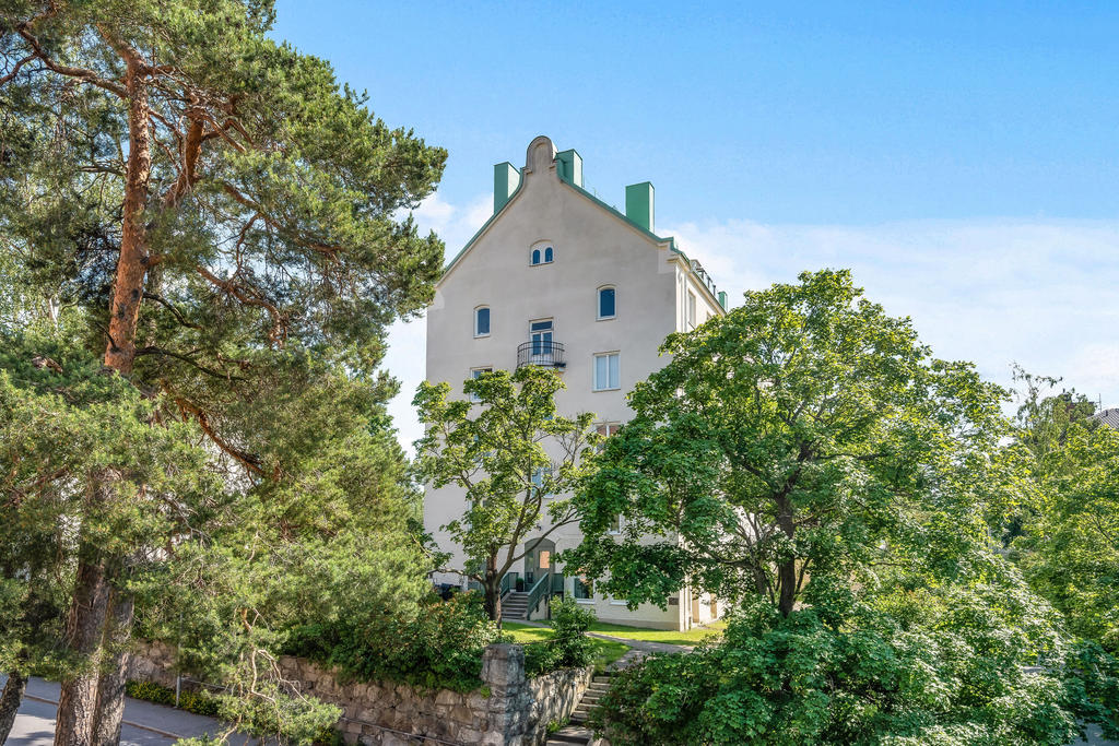 Ståtlig fastighet i jugenstil med vit puts och koppartak på  Björnvägen 8 A en sekelskiftesdröm intill grönskande natur och Lidingöbron 