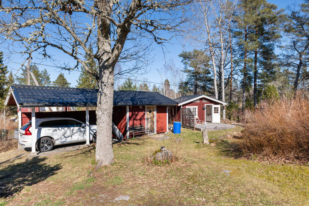 Carport med förråd, gästhuset på höger sida