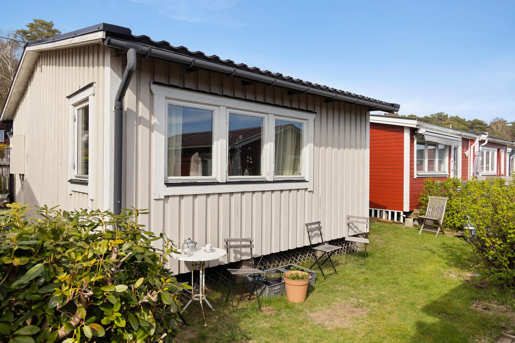 På husets baksida finns ytterligare uteplats med gräsmatta