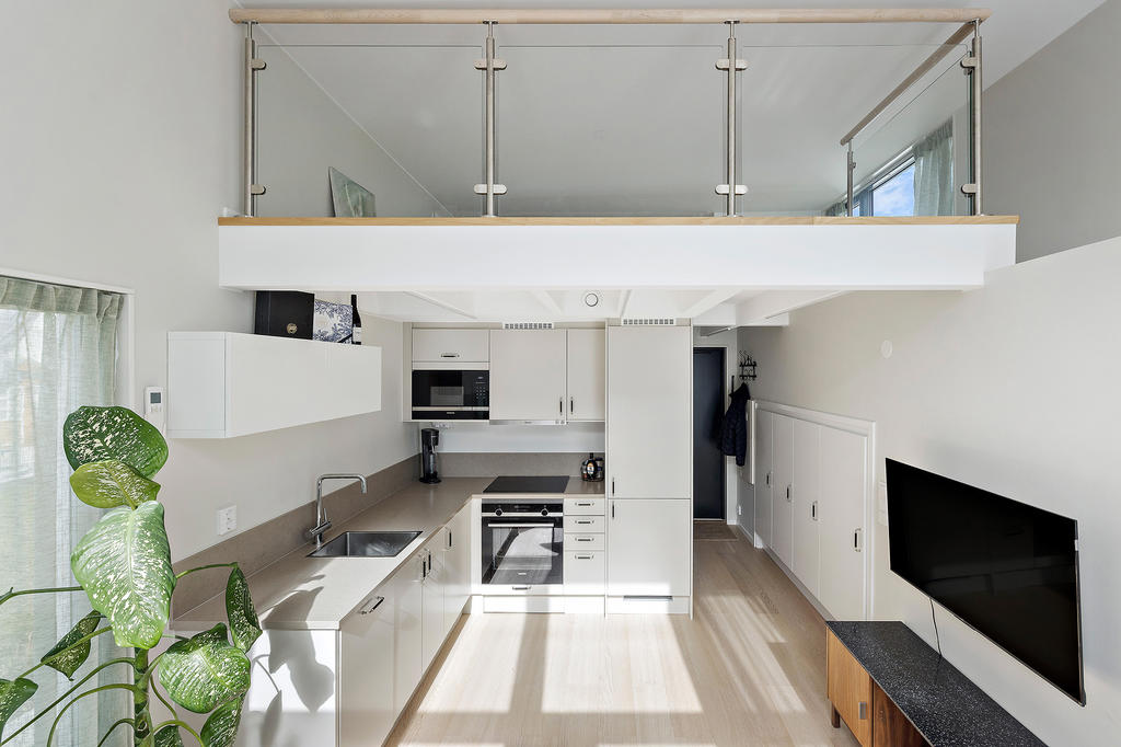 Luftig planlösning med generös takhöjd och glasräcke mot sovloftet