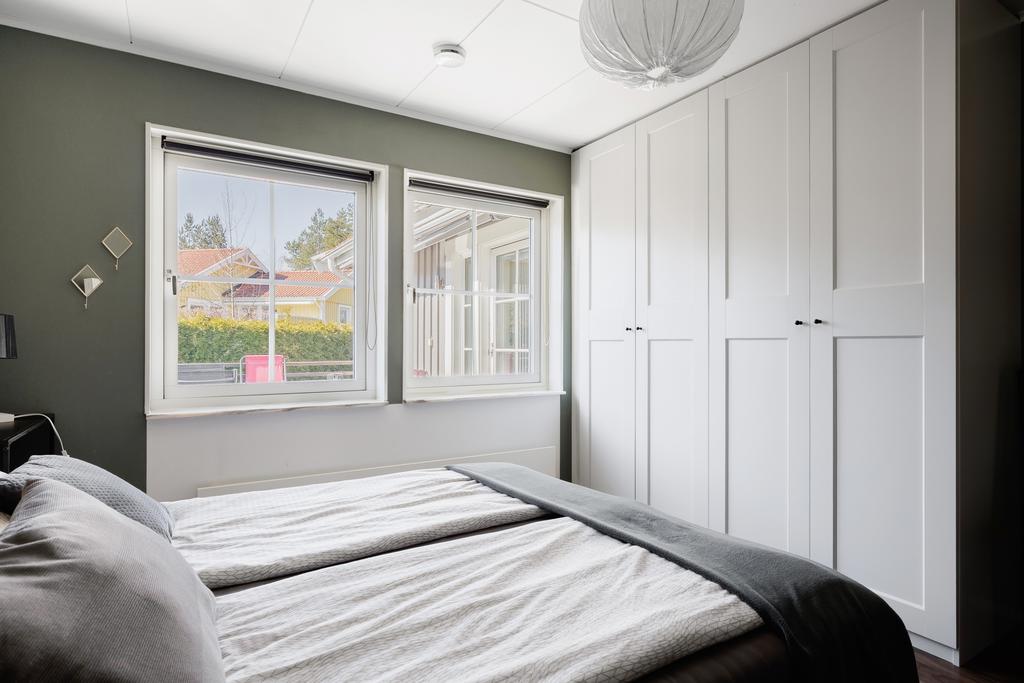 Sovrum med laminatgolv och målade väggar samt garderobsvägg