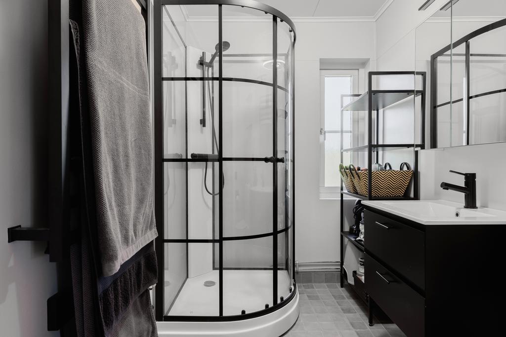 Badrum renoverat 2023 med klinkergolv och våtrumstapet, utrustat med wc, handfat med kommod, spegelskåp, handdukstork och dusch-hörna