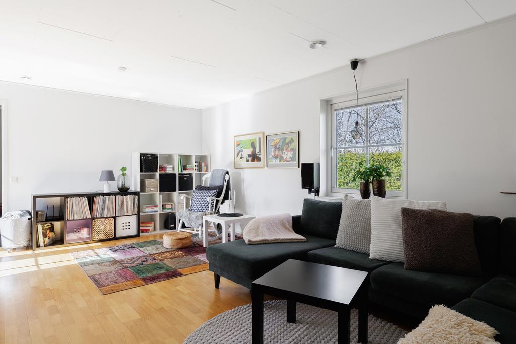 Stort och luftigt vardagsrum med parkettgolv och målade väggar