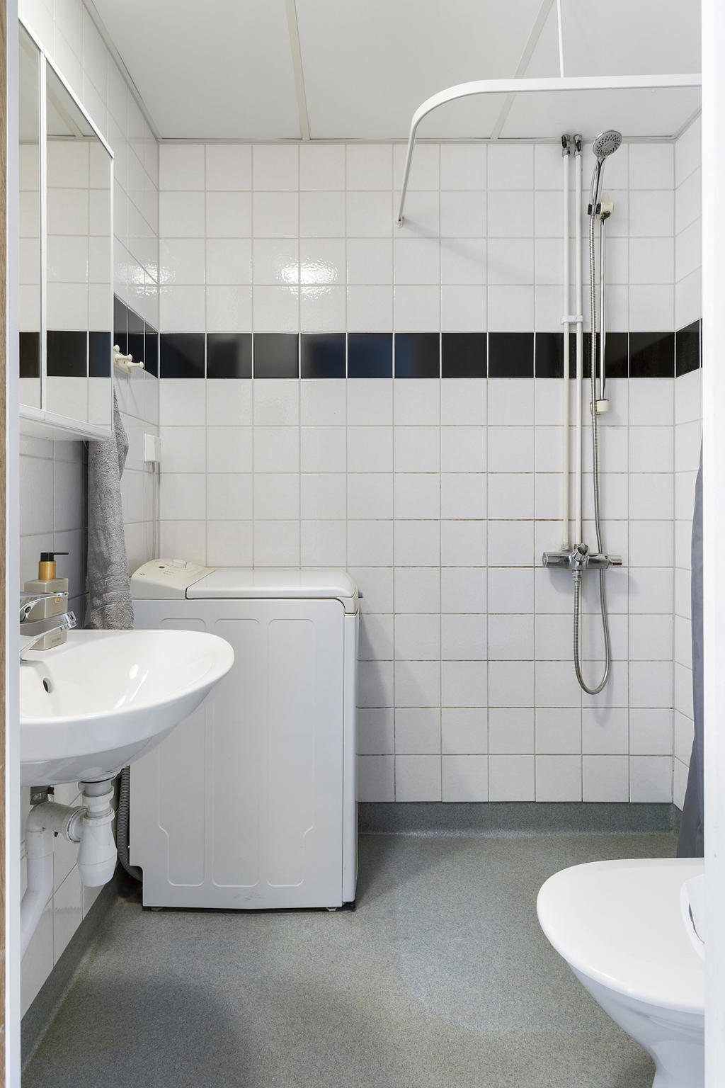 Badrum med dusch och tvättmaskin