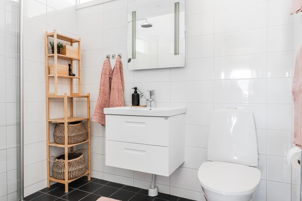 Badrum 1 med kaklade väggar, klinkergolv med golvvärme, dusch och wc