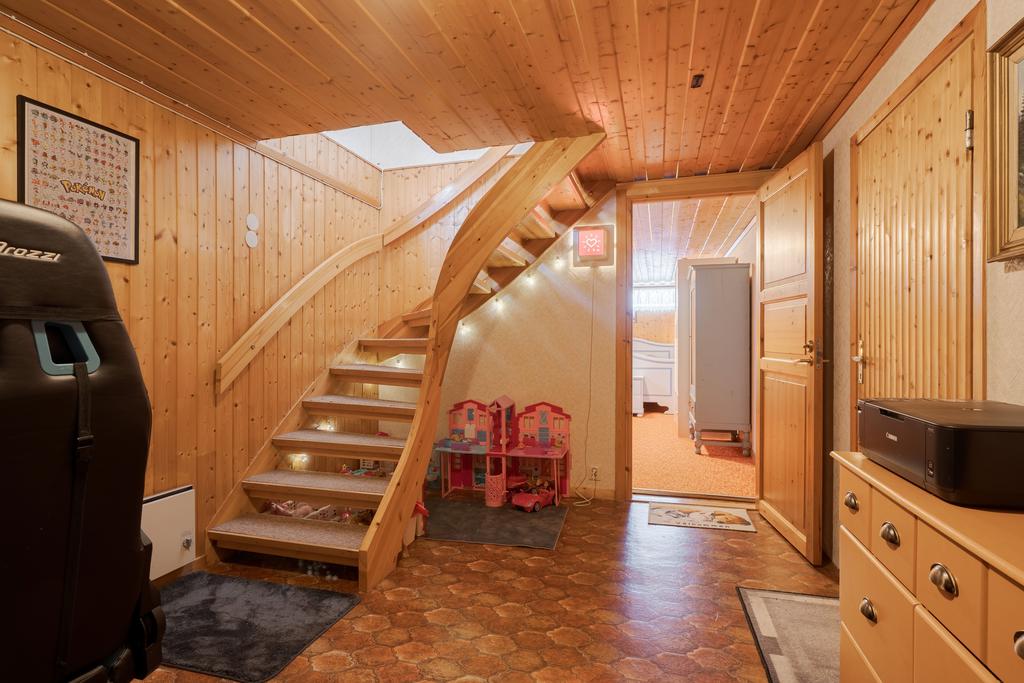 Från hallen på entréplan leder trappen ner till källarplanet. 
Här möts man av en gedigen 'hall' med gott om plats för skrivbord, spel och lek. 