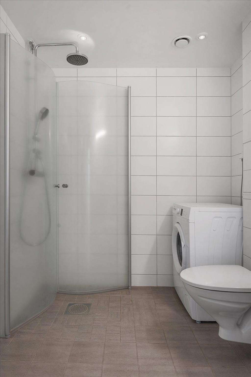 Badrum med dusch och tvättmaskin