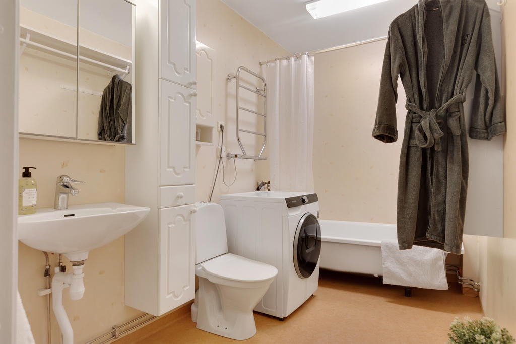 Badrum utrustat med WC, badkar, tvättmaskin, handdukstork, skåp, handfat och spegelskåp 