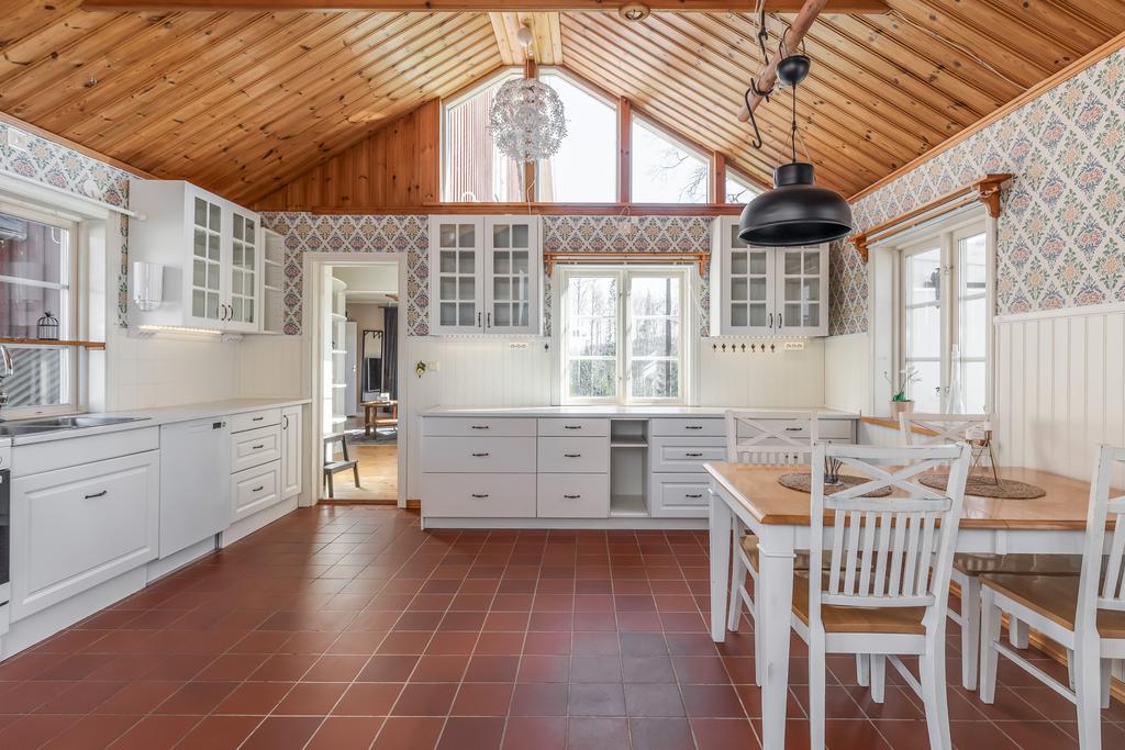 Stort kök med vattenburen golvärme samt kakelkamin med fläkt och utgång till inglasad altan.