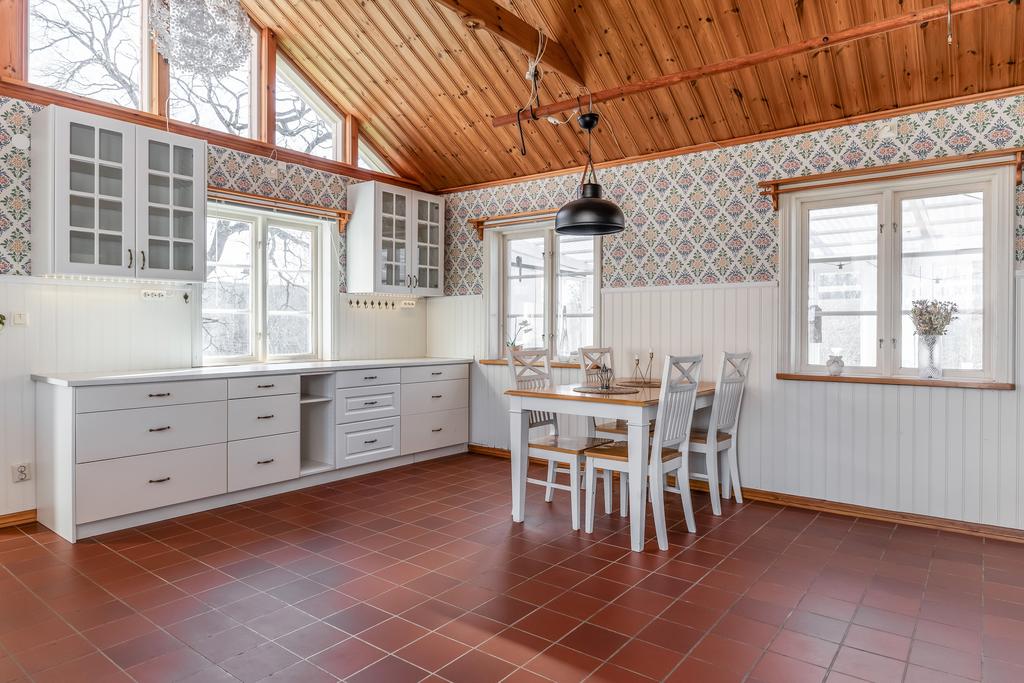 Stort kök med vattenburen golvärme samt kakelkamin med fläkt och utgång till inglasad altan.