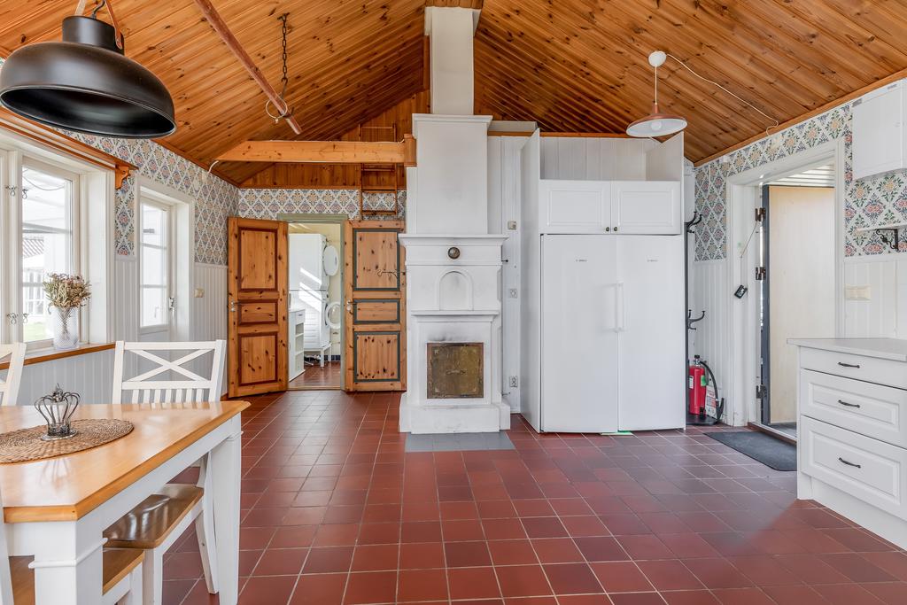 Stort kök med vattenburen golvärme samt kakelkamin med fläkt och utgång till inglasad altan.